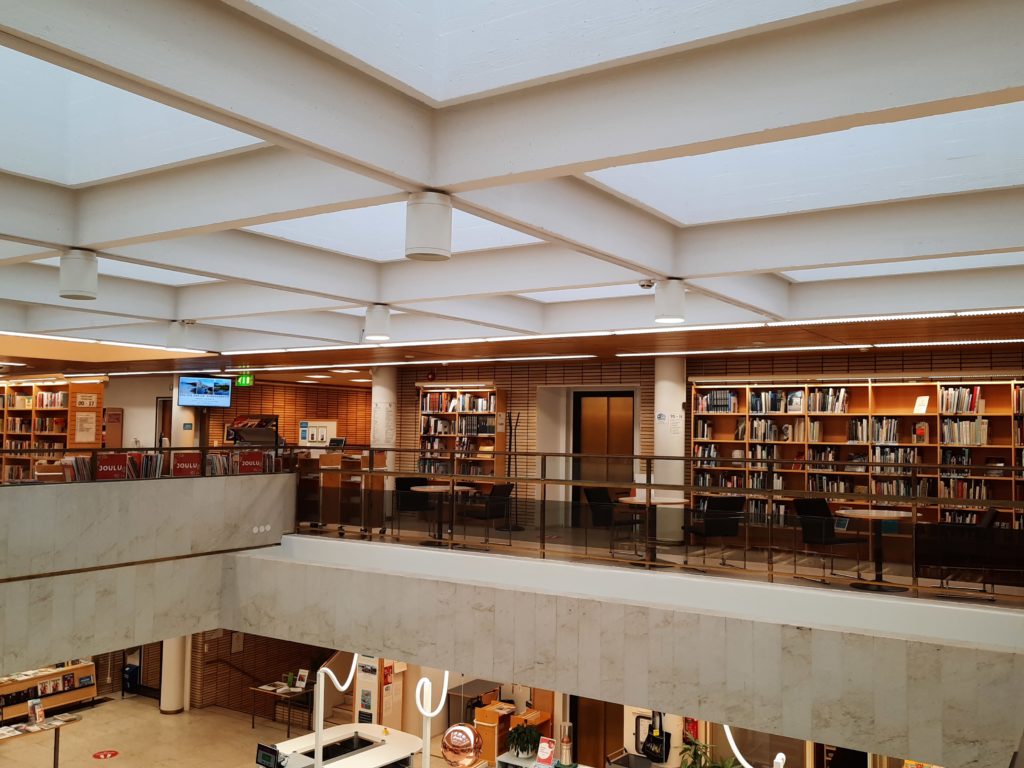 Kirjastosalin näkymä yläkerran parvelta palvelutiskille päin.