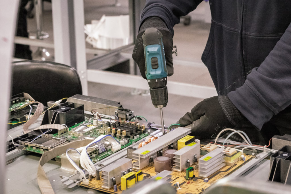Henkilö purkaa elektroniikkaa