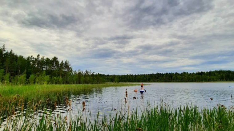 Kuvassa nuoria suppailemassa järvellä.