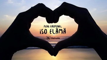 Pieni kaupunki, iso elämä teksti käsien muodostaman sydämen sisällä