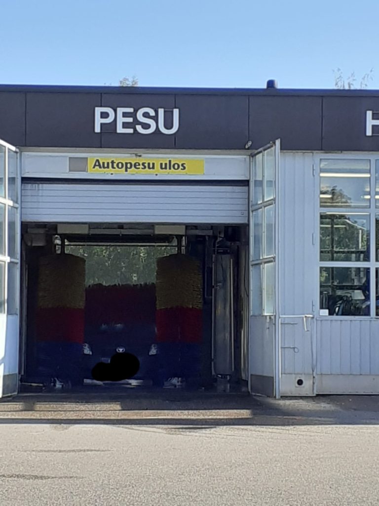 Auto on pestävänä huoltoaseman autopesulassa