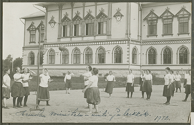 Lahden kaupunginmuseon kuva-arkisto/FINNA. Kuvassa meneillään opiskelijoiden voimistelu- uinti- ja leikkikurssi vuonna 1912. Taustalla arkkitehti Jac. Ahrenbergin piirtämä seminaarin vanha päärakennus vuodelta 1901.