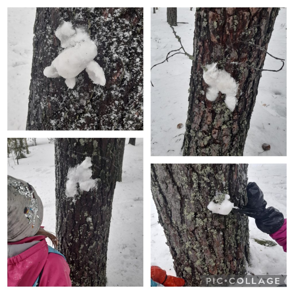 Lapset tekevät kuvioita lumella puunkuoreen