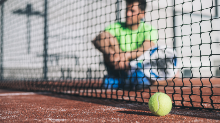 mies istuu padel kentällä