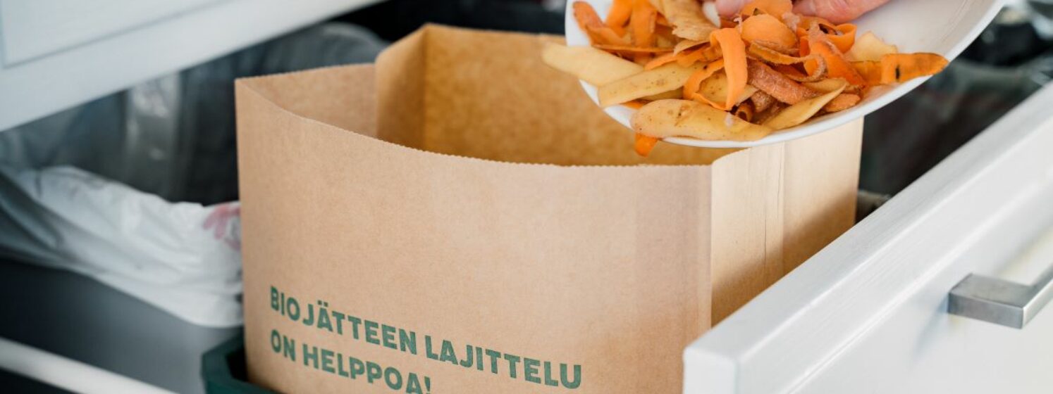 Kuvassa laitetaan biojätettä paperipussiin.