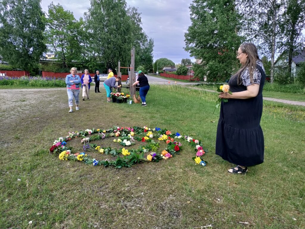 Spiraalinmuotoinen kukkataideteos nurmikolla