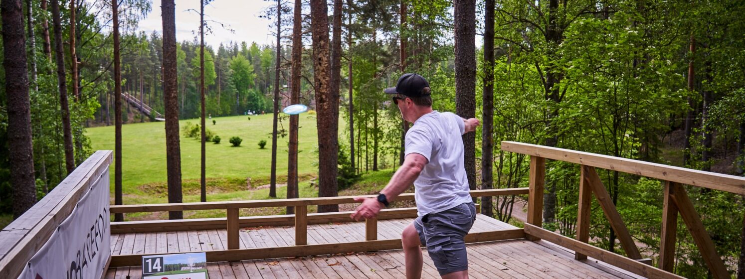 Mies heittää frisbeetä