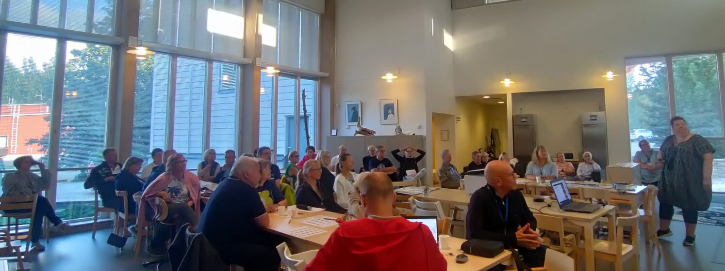 Ihmisiä asukastilaisuudessa
