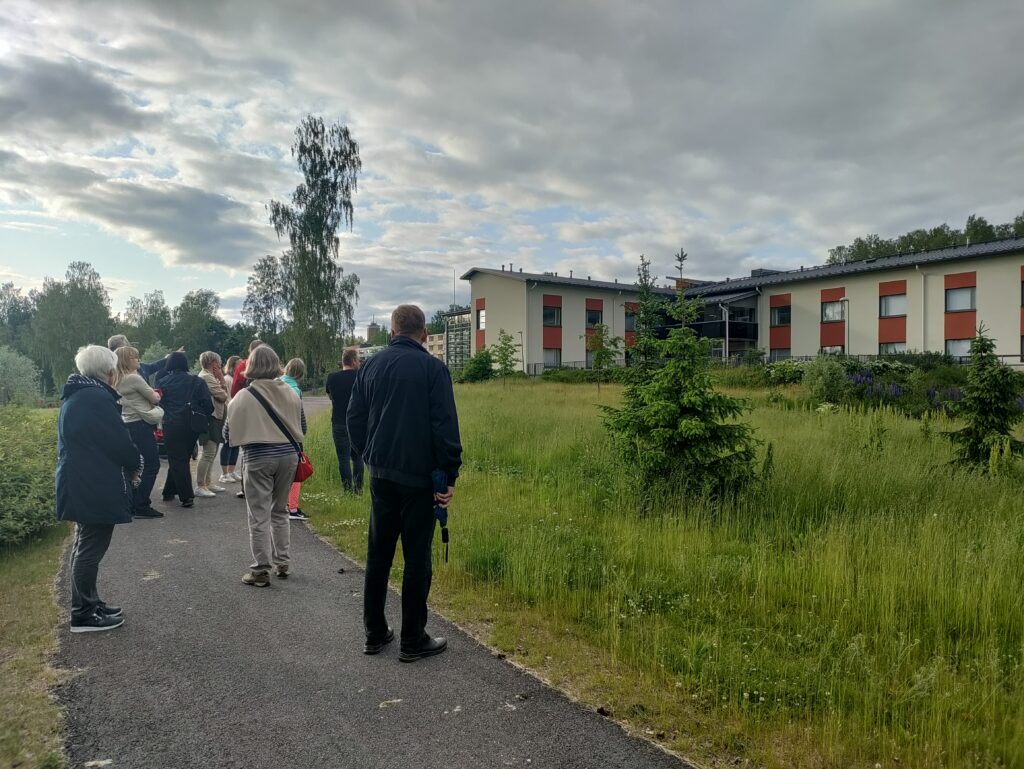 Ihmisiä tutkimassa tulevaa rakennuspaikkaa