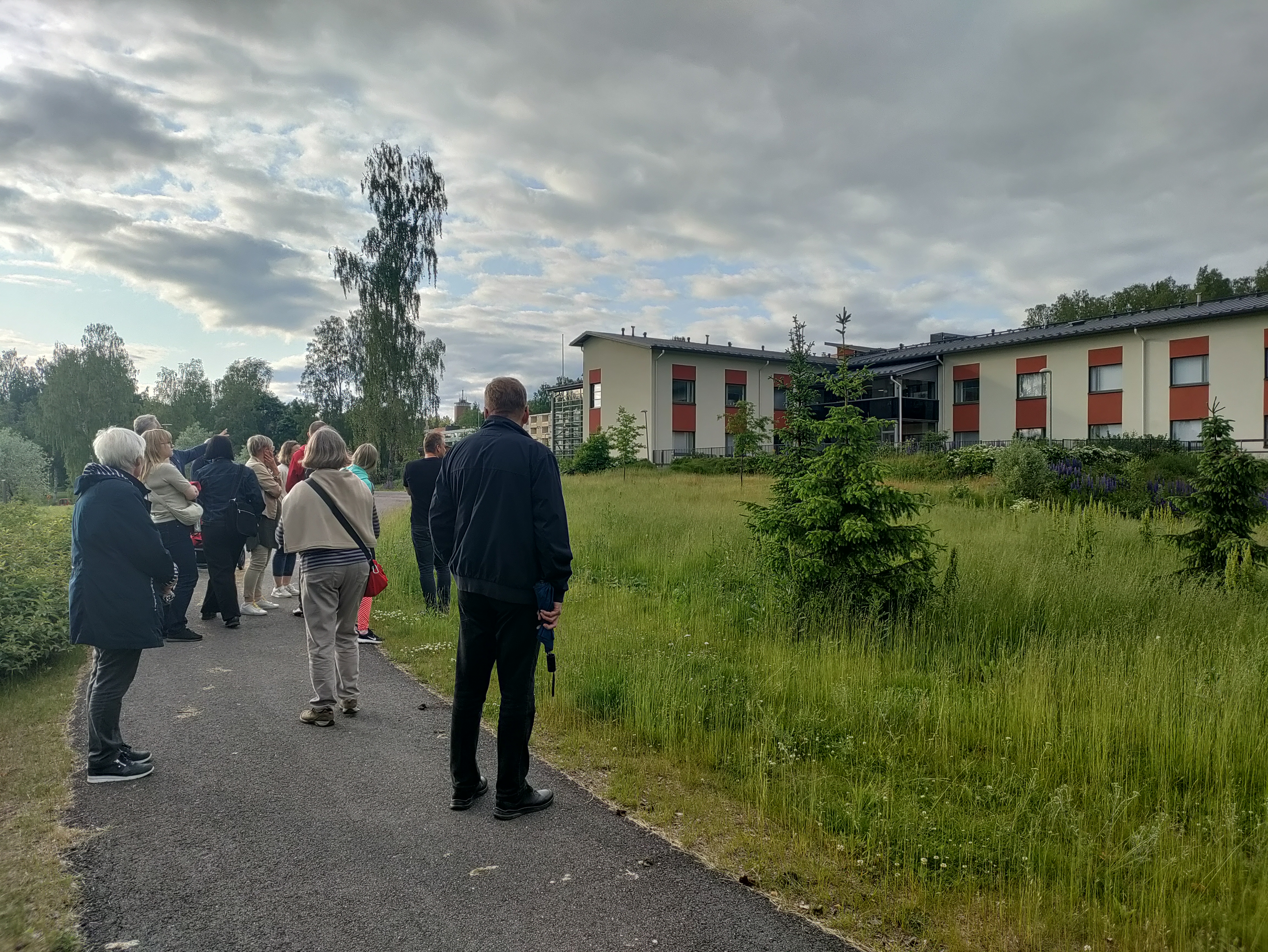 Ihmisiä tutkimassa tulevaa rakennuspaikkaa