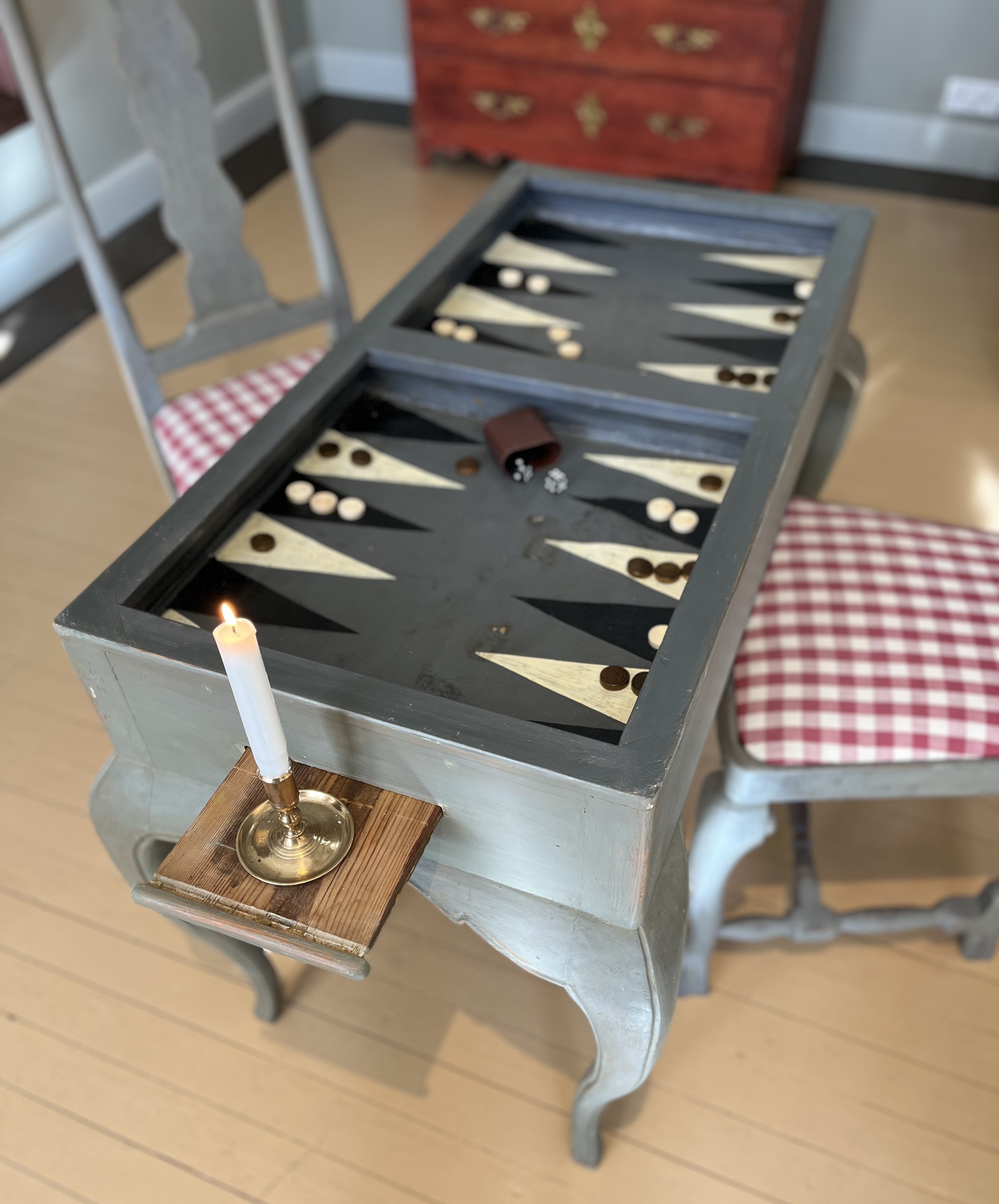 Lähikuva 1700-luvun pelipöydästä, jonka kanteen on maalattu backgammon-lauta.