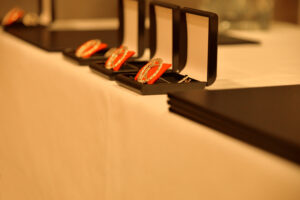 Ansiomerkit kunniakirjoineen valkoisen pöytäliinan päällä