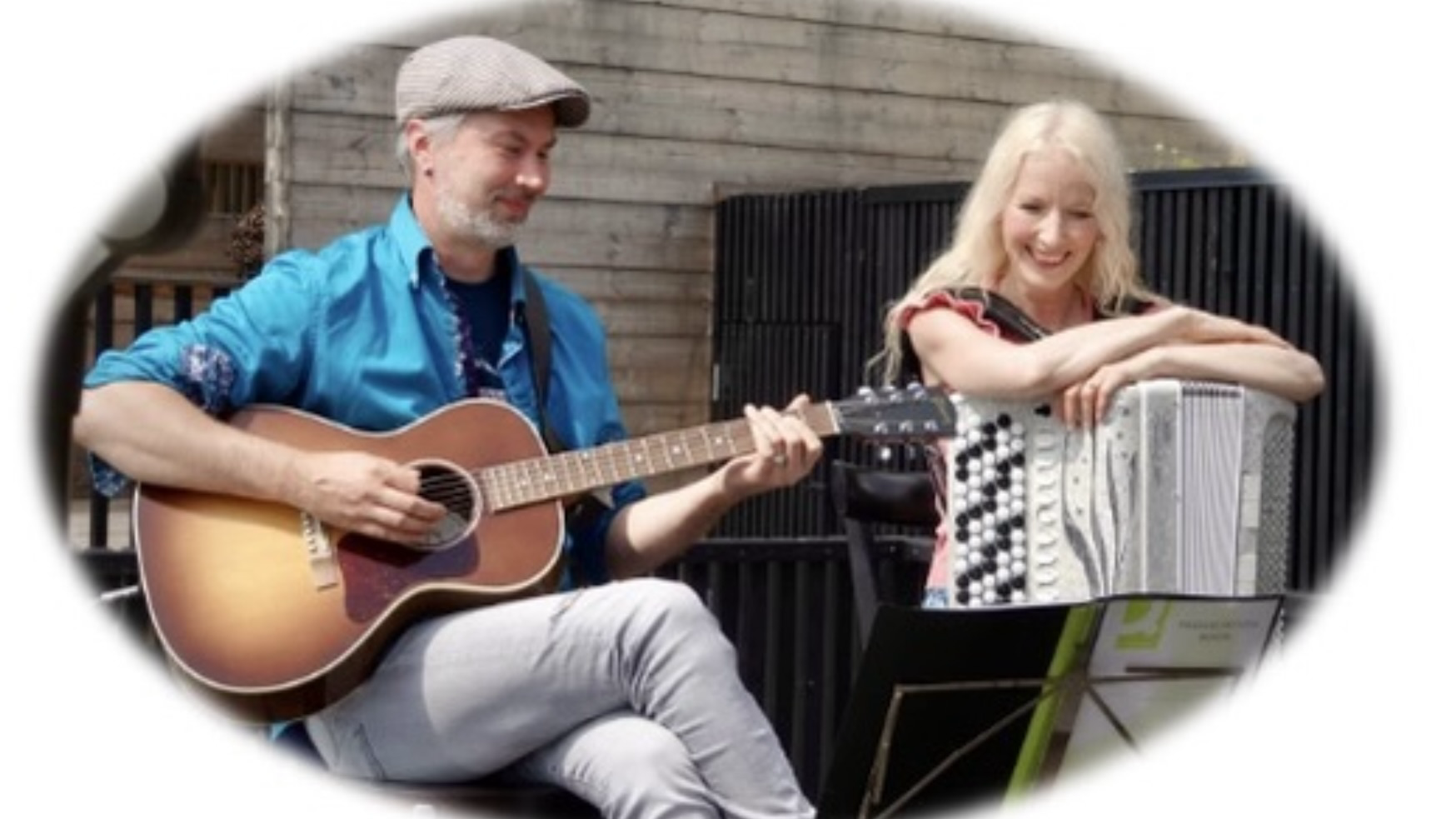 Akustista kitaraa soittava Mika Venhovaara ja haitariin nojaava Susan Aho