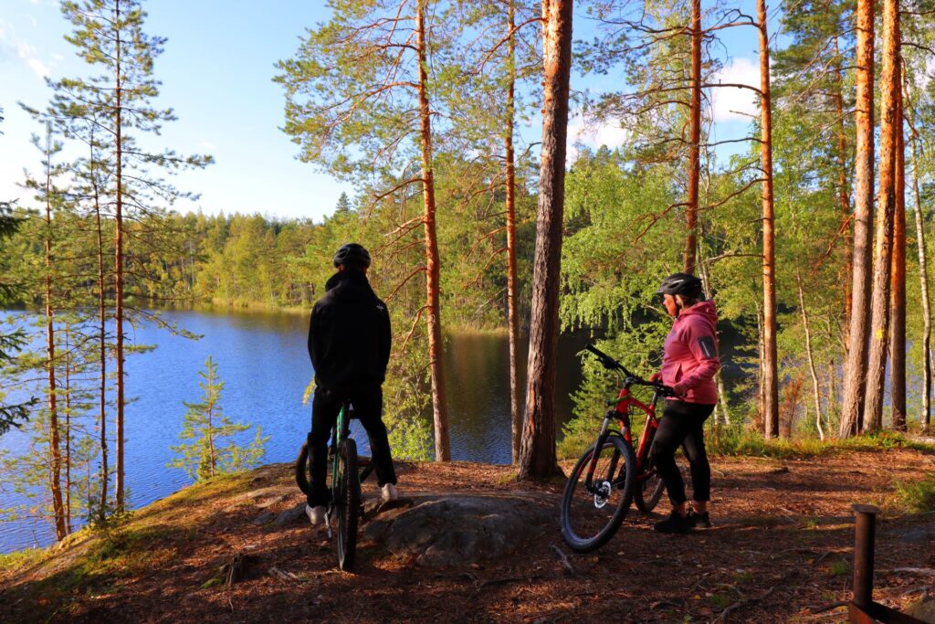 Kaksi pyöräilijää Korvenlammen rannalla.