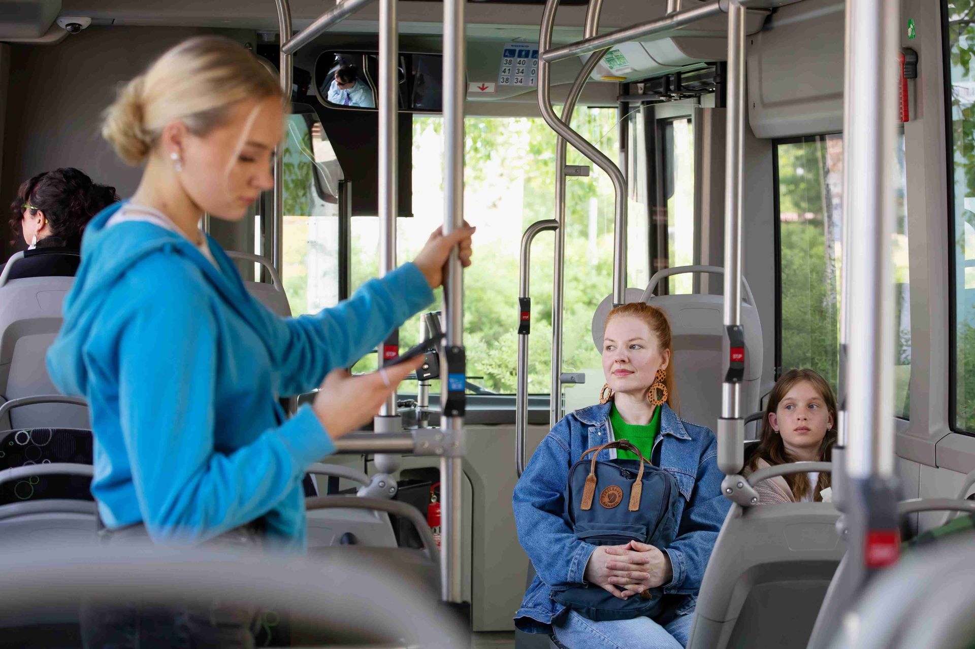 Kuvassa matkustajia linja-autossa