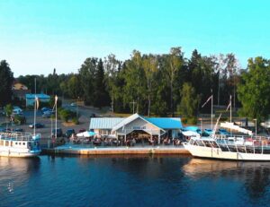 Tyyrpuuri, laivoja ja taustalla parkkipaikka sekä puisto vesiltäpäin nähtynä.