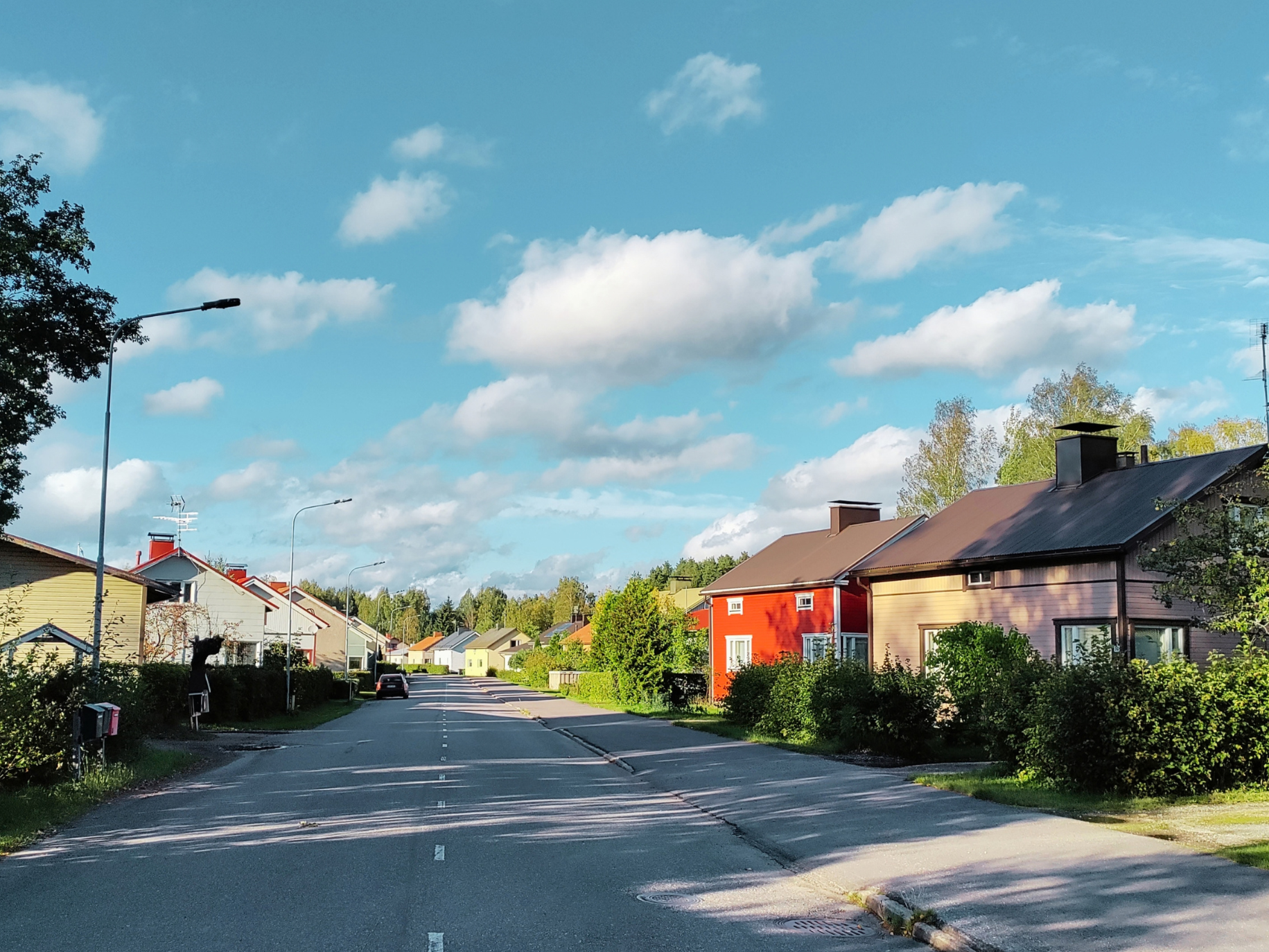 Värikkäitä omakotitaloja, sininen taivas.